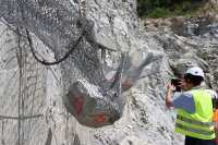 400 Kilo wiegt der Stein rechts im Bild, 550 Kilo bringt der Felsbrocken links auf die Waage: Die Forscher dokumentieren die Auswirkungen des Felssturzes auf Drahtzaun und Verankerungen.